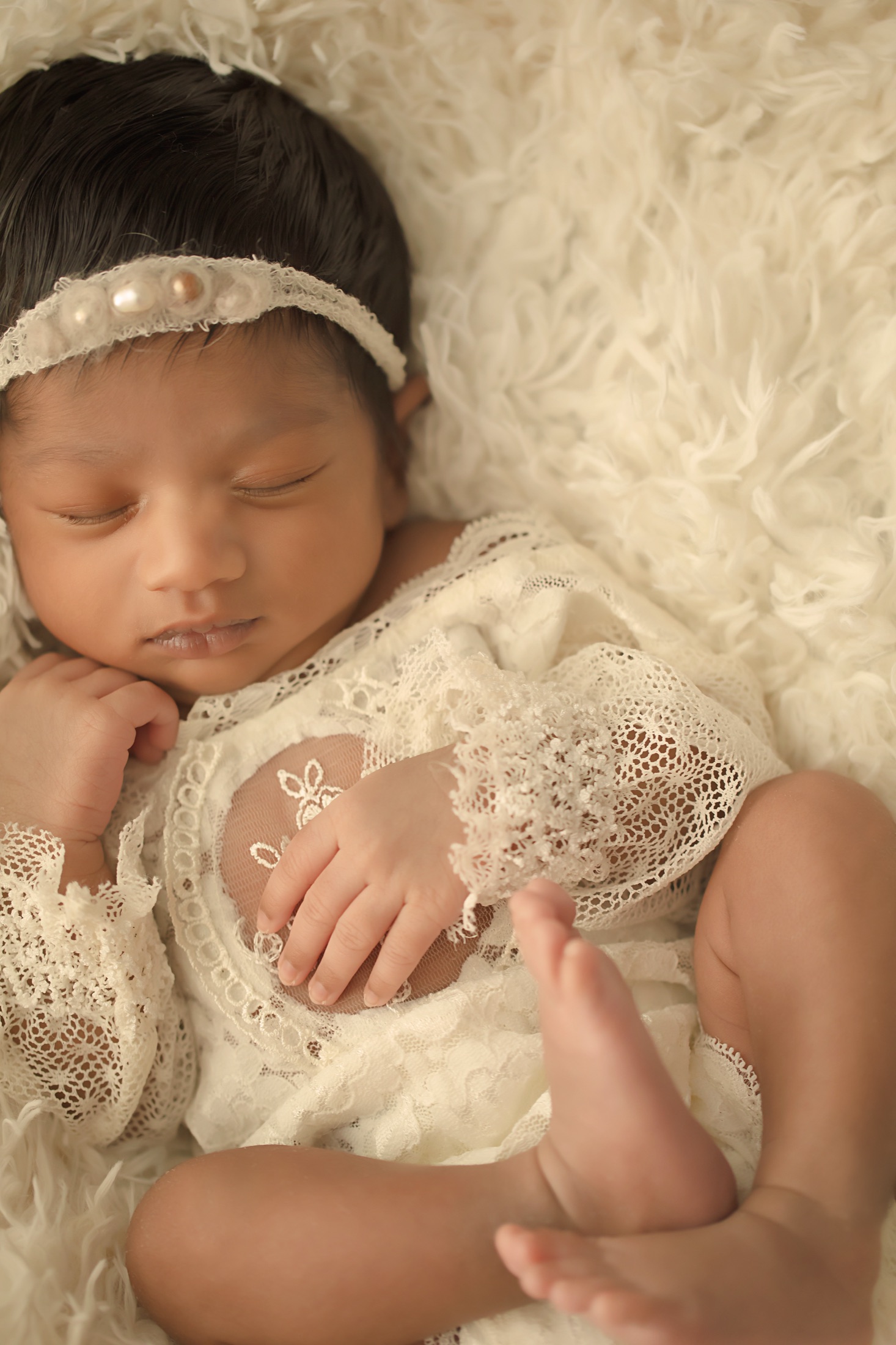 Newborn in cream lace with a pearl headband
